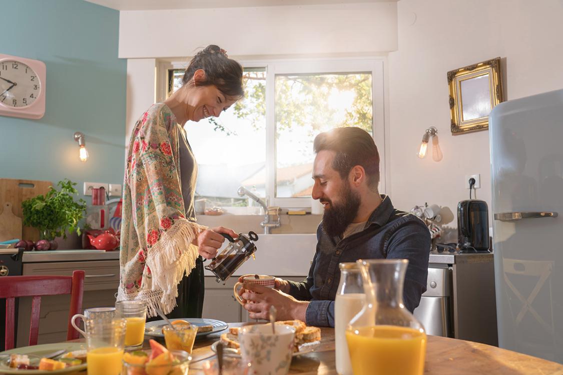 vrolijk stel in de keuken na meefinancieren boeterente voor hun hypotheek